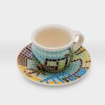 فنجان قهوة مع صحن مشغولات خزفية قرية